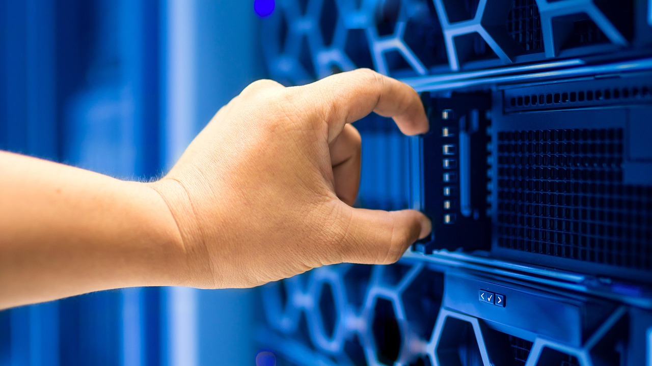 A hand working on a server in a data center rack