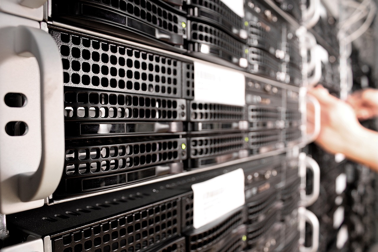 Serveurs en rack dans un data center, une main se tendant vers une unité