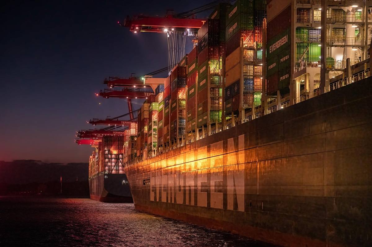 Un porte-conteneurs chargé de conteneurs empilés dans un port, de nuit